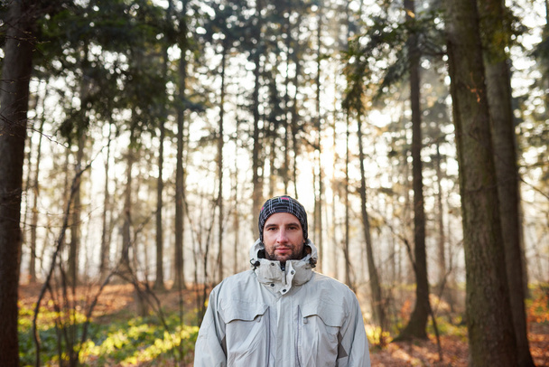 man standing in tranquil forest with sunlight - Φωτογραφία, εικόνα