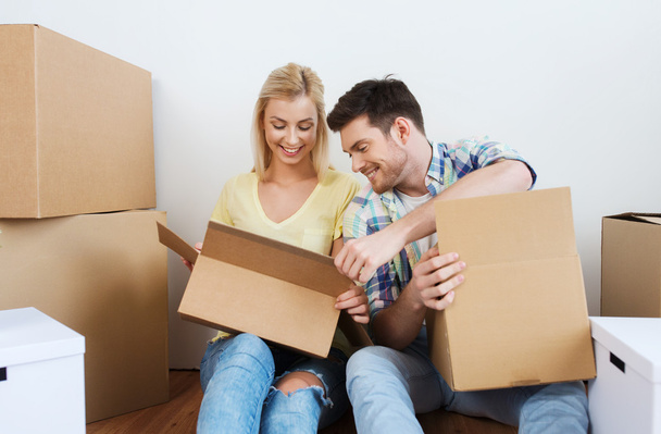 smiling couple with many boxes moving to new home - Foto, immagini