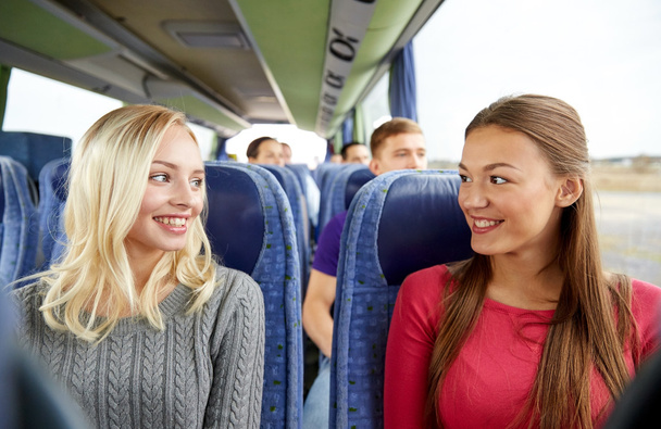 happy young women talking in travel bus - Photo, image