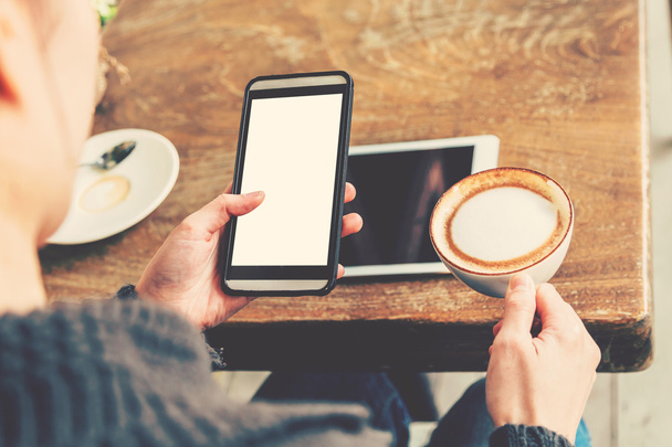 ręka kobiety za pomocą smartphone w kawiarni i miękkie światło - Zdjęcie, obraz