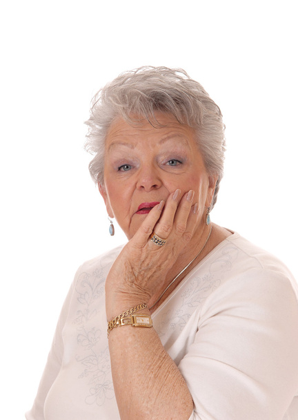 Senior vrouw Holding gezicht in haar hand. - Foto, afbeelding