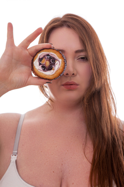 Beautiful plus size woman holding cake on her hand isolated on white background - Valokuva, kuva