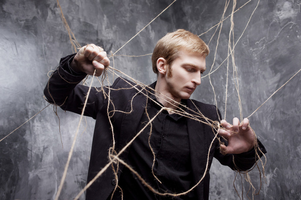 Young man tries to break the shackles. Concept of manipulation and slavery - Foto, Bild