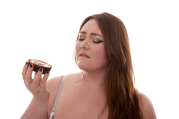 Beautiful plus size woman holding cake on her hand isolated on white background - Photo, Image