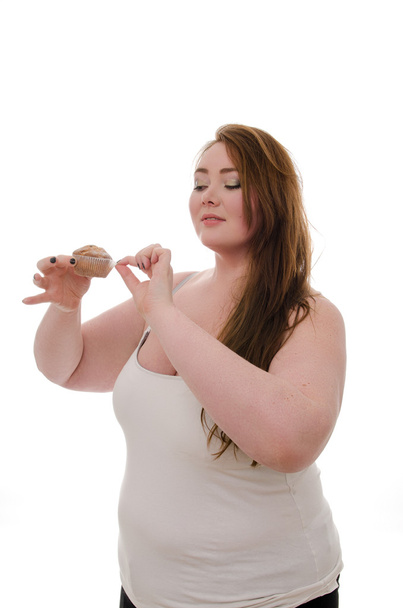 A fat woman with a muffin in her hand isolated on white background - Fotoğraf, Görsel