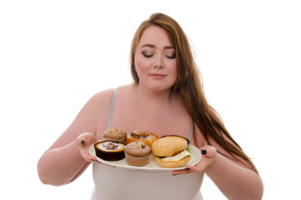 the fat woman with cakes and burgers on a platter in her hands isolated on white background - 写真・画像