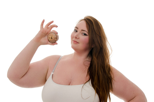 A fat woman with a muffin in her hand isolated on white background - Φωτογραφία, εικόνα