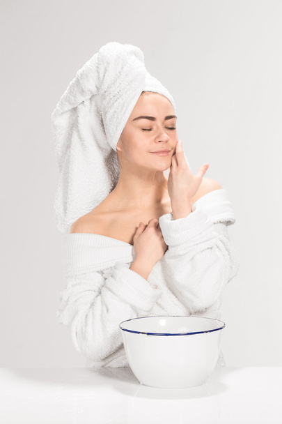 Woman cleaning face in bathroom - Fotó, kép