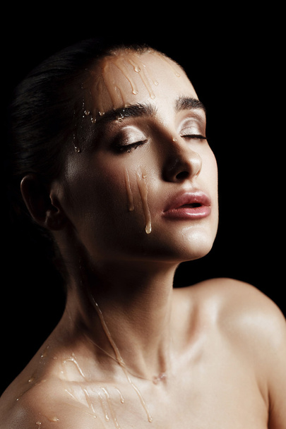 Beauty Portrait of Young Woman with Strobing Makeup Liquid on Fa - Fotó, kép
