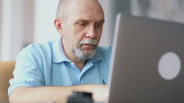 Ανώτερος άνθρωπος λειτουργεί με φορητό υπολογιστή - Πλάνα, βίντεο