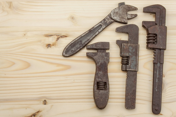 Old rusty mechanics tools on a wooden background. Advertising for new tools. Sales tools. Place for your text. - Foto, afbeelding
