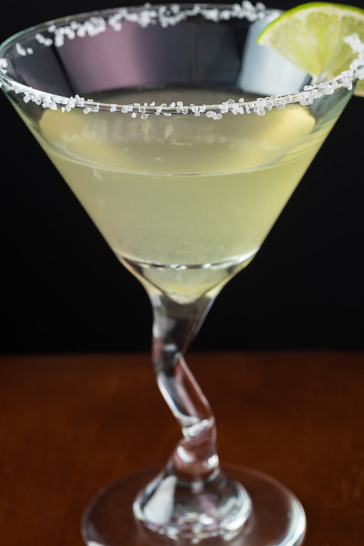 Classic margarita cocktail garnished with salt rim,  lime wheel  - Фото, изображение