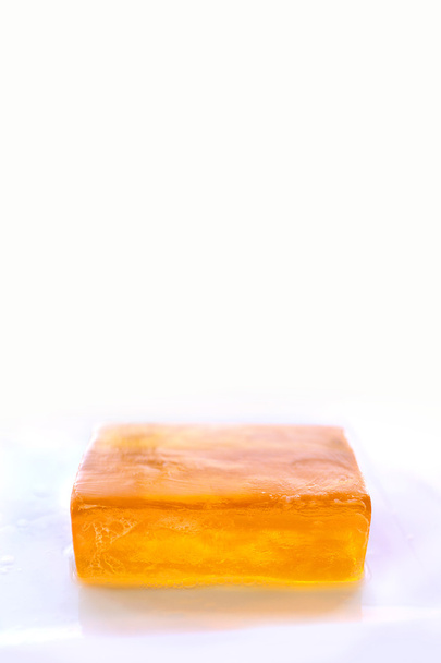 Barra naranja de jabón de glicerina aislada sobre fondo blanco
 - Foto, imagen