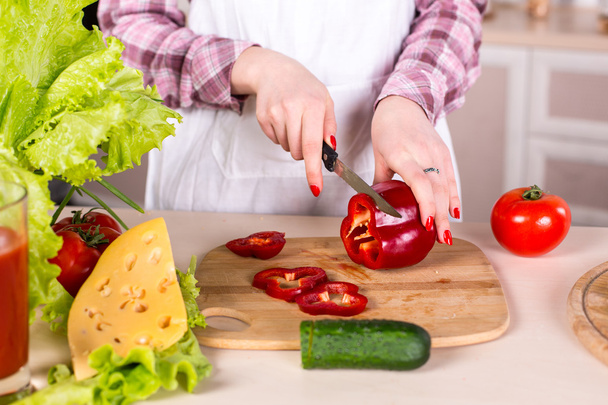woman slicing pepper on woden board - Photo, Image