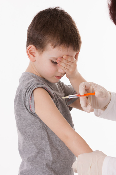 Arzt spritzt Kind auf isoliertem Bild Injektion in Arm. - Foto, Bild