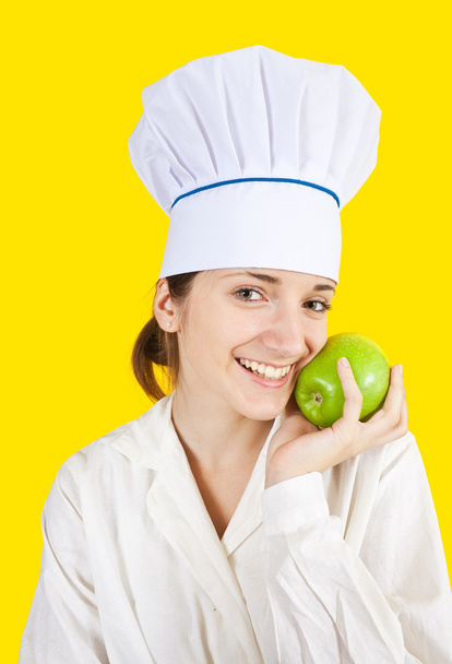 Female chef holding green apple - Foto, afbeelding