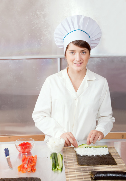 Cook woman making sushi rolls - Фото, изображение