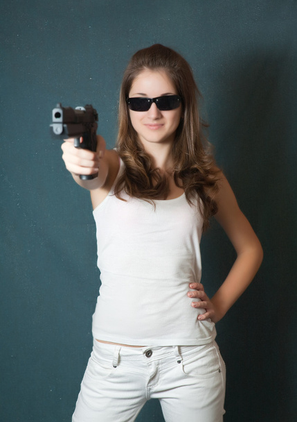 Girl in sunglasses aiming a gun - Фото, зображення