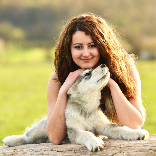 若い犬のマラミュートと美しい女性 - 写真・画像
