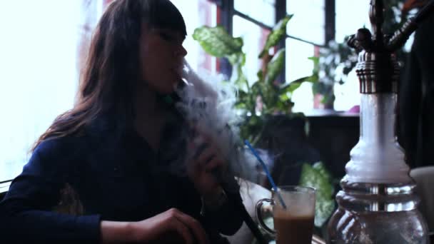 Hermosa mujer joven inhalando narguile. chica fumando shisha en la cafetería. Silueta
 - Imágenes, Vídeo