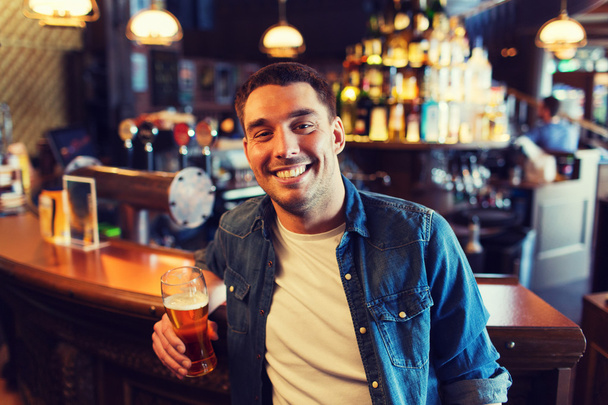 happy man drinking beer at bar or pub - Фото, зображення