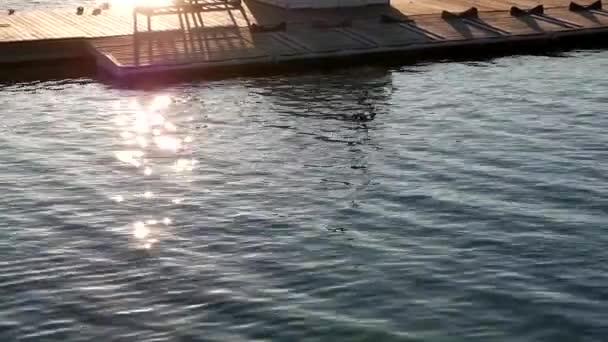 Ποταμός αποβάθρα με ήλιο ακτινοβολούν γούρνα στο βραχώδες σημείο park - Πλάνα, βίντεο