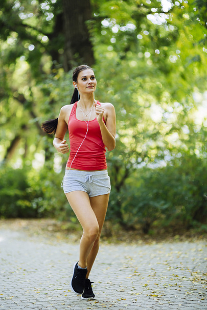 Young beautiful athlete jogging in park - Foto, imagen