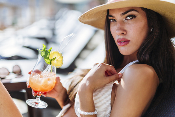 Woman holding cocktail while sunbathing - Valokuva, kuva