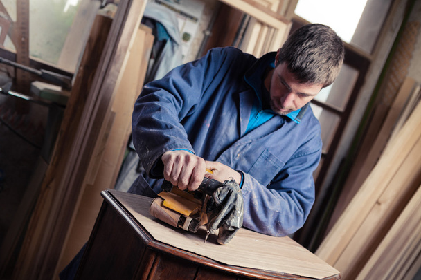 Carpintero restaurando muebles con lijadora de cinturón
 - Foto, imagen