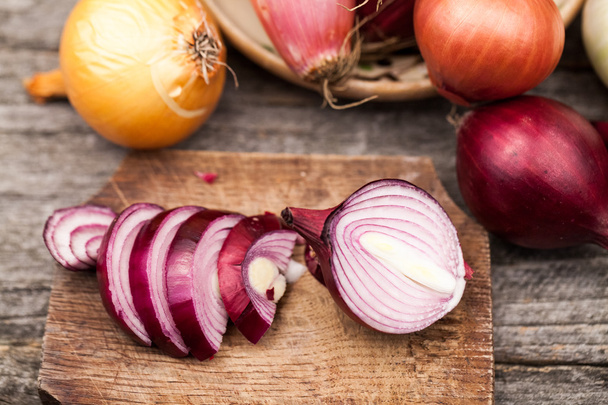 Different types of onions on a wooden surface - Foto, Bild
