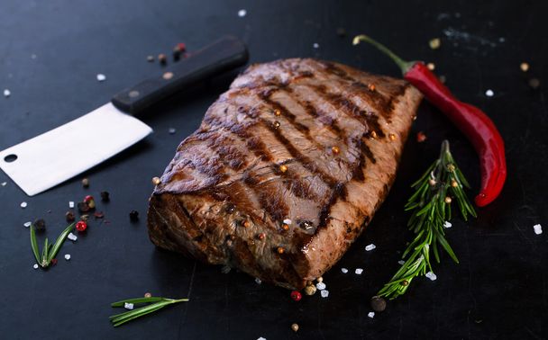 Grilled Beef Steak with spices, rosemary and chili peppers - Photo, Image