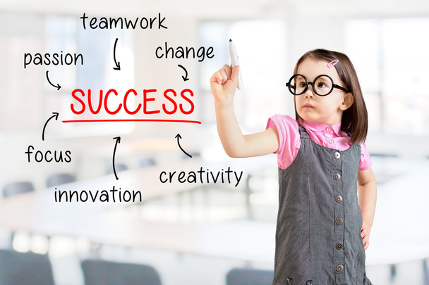 Cute little girl wearing business dress and writing success diagram on glass board with marker. Office background. - Foto, Imagen