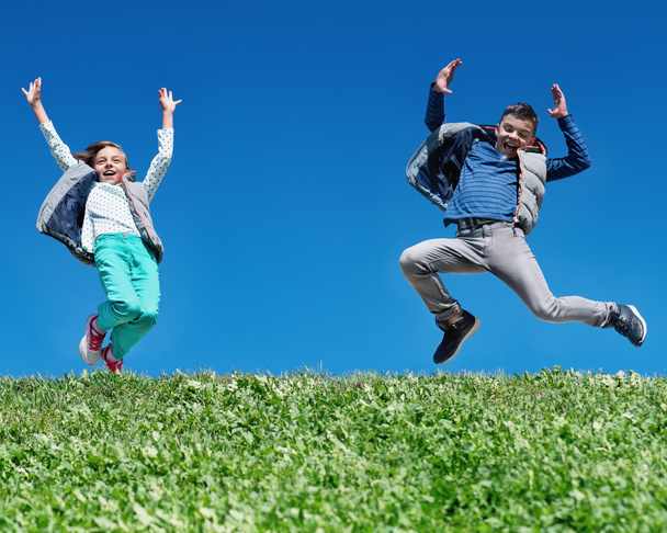 Счастливые дети прыгают по лугу
 - Фото, изображение
