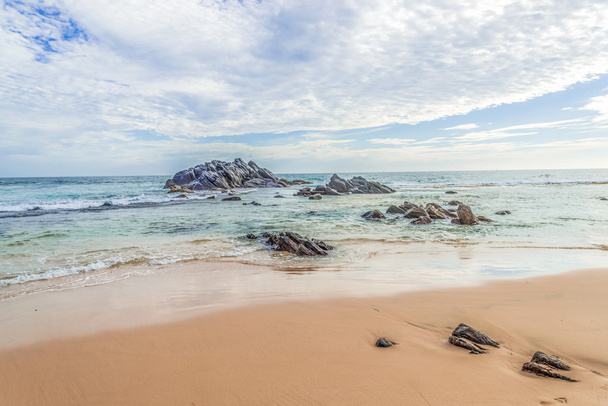 Αμμώδης παραλία με βράχια στον ωκεανό. - Φωτογραφία, εικόνα
