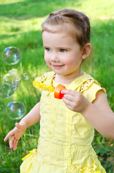 Portrait of little girl blowing soap bubbles - Фото, зображення