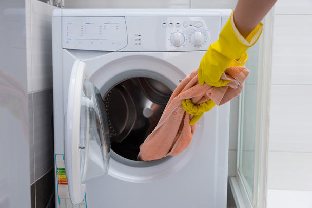 Hand pulling towel out of washing machine - Photo, image