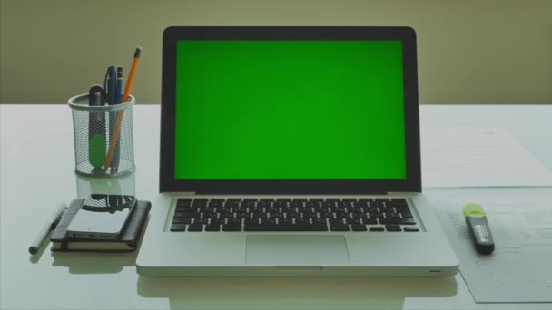 Φορητό υπολογιστή με πράσινη οθόνη (Chroma-κλειδί) στο μοντέρνο γυάλινο τραπέζι στο γραφείο 4k - Πλάνα, βίντεο
