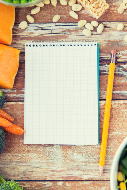 close up of ripe vegetables and notebook on table - Photo, image