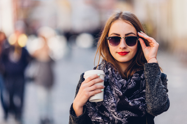 Young girl walking on the street with cup of hot coffee - Foto, immagini