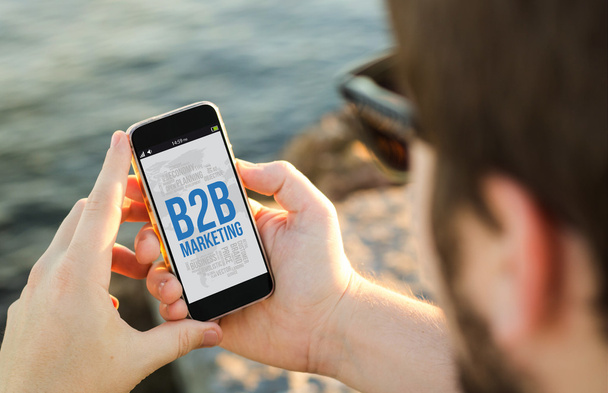 Hombre usando el teléfono en la costa con b2b marketing
 - Foto, Imagen