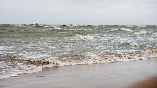 Balti-tengeri strandtól, ősszel a felhők és a hullámok felé sivatagos dűne - Fotó, kép