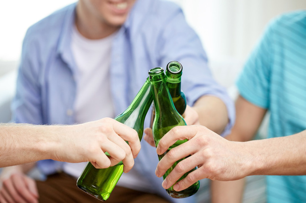 close up of male friends drinking beer at home - Fotoğraf, Görsel