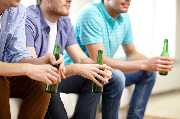 happy male friends with beer watching tv at home - Foto, afbeelding