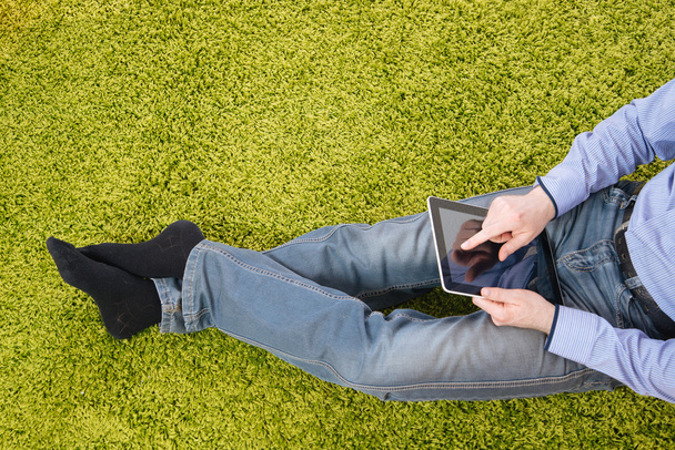young man sitting on a carpet with tablet - Foto, Bild