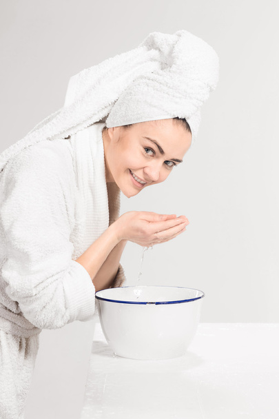 Young woman washing face with clean water - Foto, Bild