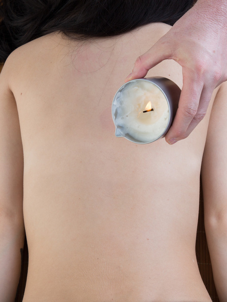 Primer plano de una mujer joven recibiendo masaje de vela de hombro en el spa
 - Foto, imagen