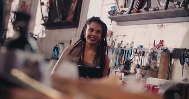 Artesana Hipster usando una tableta digital en un taller de reparación
 - Metraje, vídeo