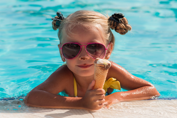 on a sunny day the girl in sunglasses with ice cream relaxing in the pool - Foto, Bild