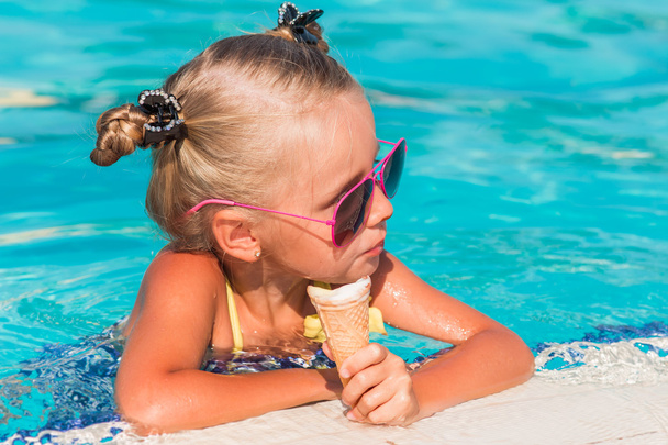 on a sunny day the girl in sunglasses eating ice cream - Foto, Imagen