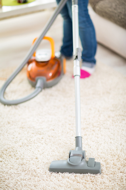 Vacuuming carpet with vacuum cleaner - 写真・画像